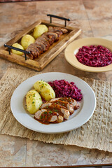 pork shwienbraten served with boiled potatoes and sauteed red cabbage