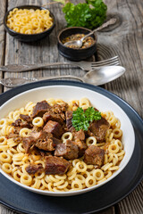 pasta rings topped with braised meat in bowl