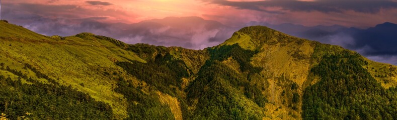 Obraz premium Rolling mountain,glow golden sky and winding valley grass view form a vast scenic scene High quality panorama photo Hehuanshan,Nantou Taiwan For branding calendar screensaver website banner postcard