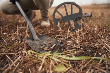 Man found old bullets and coin, sapper, close up view, with shovel