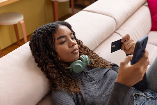 Young adult woman at home shopping on smartphone mobile