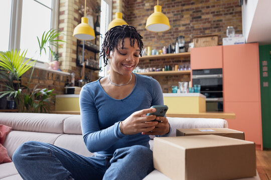 Young African American woman selling on an online marketplace using her phone