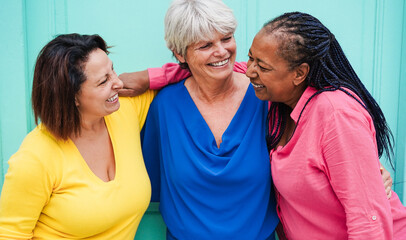 Multiracial senior women having fun hugging together outdoor - Joyful 50's lifestyle, diversity and...