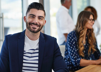 Obraz premium Creative, coworking and portrait of man in office with smile, confidence and collaboration at startup agency. Meeting, team and designer in conference room with happy face, business people and pride