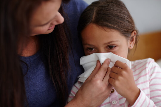 Mother, daughter or blowing nose with tissue for sneeze, flu or cold for virus, hayfever or sinus at home. Mom, girl or helping sick child with mucus, symptom or viral infection for allergy or cough