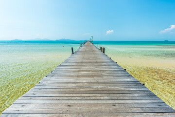 Long wooden bridge go to the sea in beautiful tropical island, Thailand.
