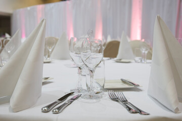 Elegant dinner setting with carefully arranged tableware in a softly lit venue for a special occasion