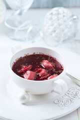 Traditional Christmas Borscht (Barszcz) with mushroom dumplings on bright background.