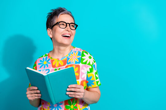 Portrait of pretty aged lady hold book look empty space wear t-shirt isolated on turquoise color background