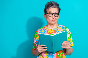 Photo of nice aged woman read book think empty space wear t-shirt isolated on teal color background