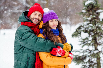 Photo of sweet charming marriage couple wear windbreakers enjoying snowy weather cuddling smiling...