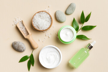 Coconut with jars of coconut oil and cosmetic cream on colored background. Top view. Free space for your text. Natural spa coconut cosmetics and organic treatment concept Coconut Spa composition