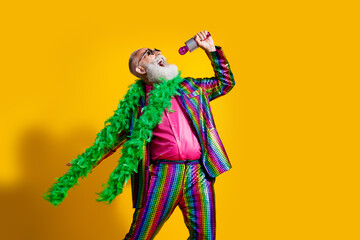 Photo of elderly cool old man enjoy loud sing karaoke wear stylish striped suit boa sunglass isolated on yellow color background