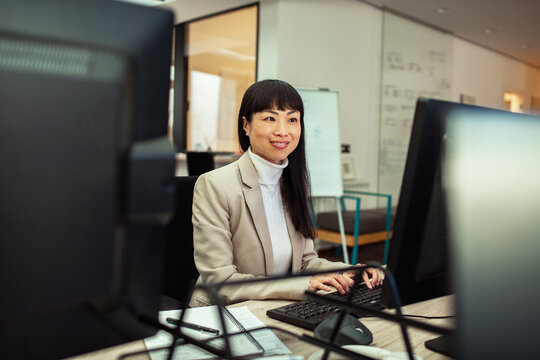 Asian businesswoman working on computer in company office
