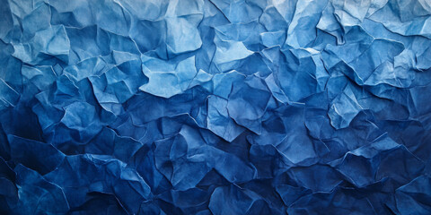 Fototapeta premium Textured blue crumpled paper with creases in varying depths. Shades of navy and sky blue create contrast and a rich layered effect.