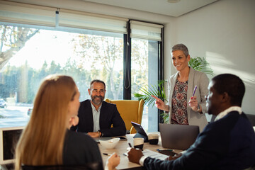 Team collaboration in modern office space with diverse professionals using laptops and discussing...