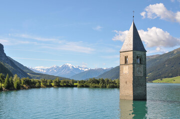 Paisaje y campanario de la iglesia del pueblo de Graun sumergido bajo las aguas del lago Resia en la comunidad de Bolzano, Italia