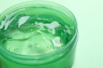Top view of organic aloe vera or cucumber gel for skin care. Natural gel in jar on green background