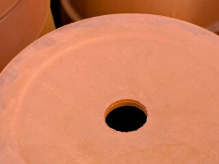 Image of close up of bottom of large terracotta flowerpot showing drainage hole