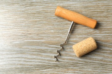 Wine corks with corkscrew on wooden background 