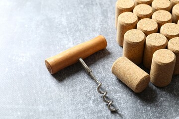 Wine corks with corkscrew on gray background 