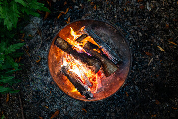 A fire burns at night in a barbecue in the forest.