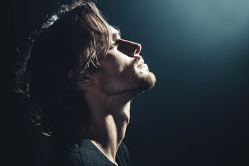 Obraz premium Side Profile of a Thoughtful Man in Dramatic Lighting