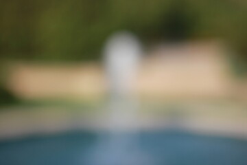 A dreamy view of a tall water fountain in the park.