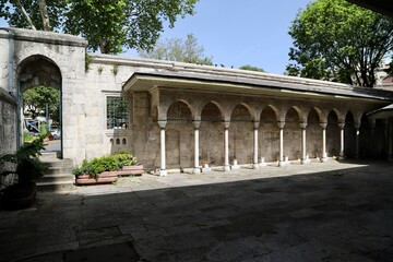 Obraz premium Ablution fountains of the historic Kilic Ali Pasha Mosque, with an arched roof structure supported by columns. 