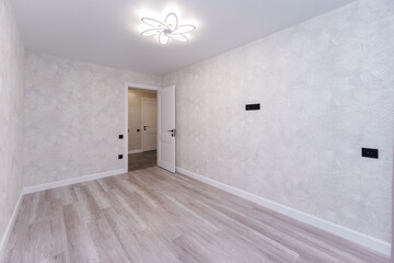 empty room without furniture in light colors with a chandelier and curtains
