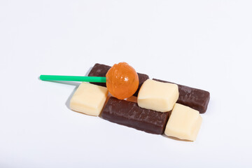 Creamy chocolate and orange lollipops on a white background