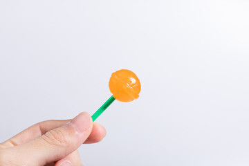 With orange lollipops in your hands