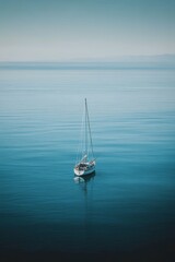 Fototapeta premium Sailboat floats, serene ocean vastness.