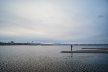 Obraz premium A dog playing throw and catch ball with his owner at the edge of a beautiful lake in the afternoon