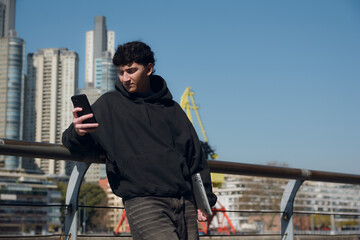 Young male content creator, traveling in Argentina, calmly checking his phone outdoors