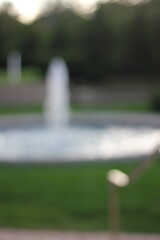 A dreamy view of a tall water fountain in the park.