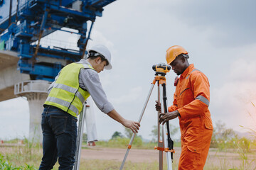 Surveying engineers take measurements with theodolite instruments at construction sites. Surveyors...