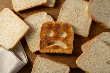 Gluten food, slice of toasted bread with sad face. Gluten allergy concept