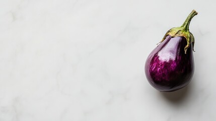 A single, ripe eggplant with a glossy purple skin placed on a white marble surface with ample negative space for a clean, minimalist presentation.