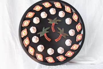 A creative display of khachapuri, khinkali, and palm tree magnets arranged on a black tray, combining food symbolism with artistic design for an eye-catching home decor piece