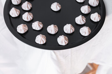 Close-up of khinkali magnets, placed on a black tray in an organized design that emphasizes the handmade craftsmanship and vibrant details