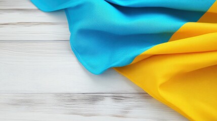 The image features a vibrant blue and yellow fabric draped over a white wooden surface, showcasing softness and color contrast.