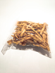 A clear plastic package of crispy prawn sticks (jejari udang), a popular Malaysian snack made from prawn-flavored dough, fried to golden perfection, perfect for any occasion.