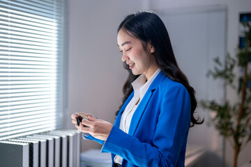 A woman in a blue suit is holding a cell phone