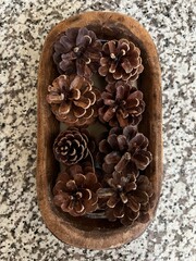 pine cones in wooden bowl