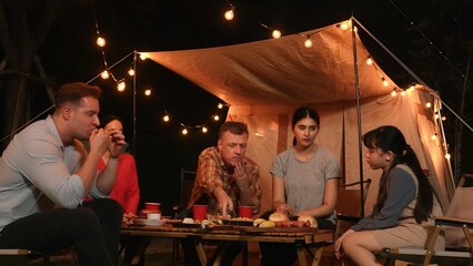 Family gather for holiday celebration in garden. Family member gather have dinner. Outdoor camping...