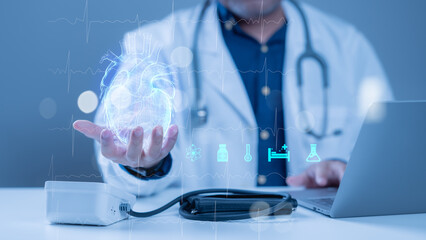 A doctor is holding a heart in his hand while looking at a laptop. The laptop screen shows a heart with a blue glow and a few other medical symbols. Concept of hope and healing