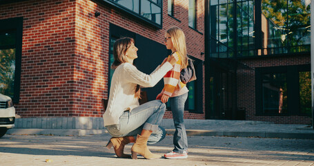 Side camera view of Caucasian mother sitting in front of her kid. Talking with daughter before...