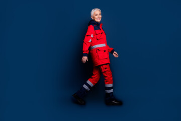 Full size photo of attractive mature lady profile walking wear uniform paramedic doc insurance assistance isolated on dark blue background