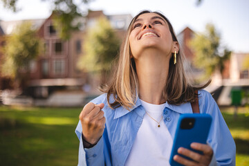 Blonde short hair woman browsing internet with cellphone mobile phone wearing casual clothes shirt...
